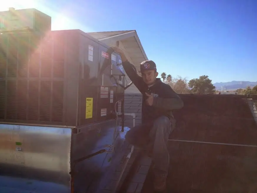 HVAC technician performing Air Duct Cleaning on a rooftop unit in Rittman