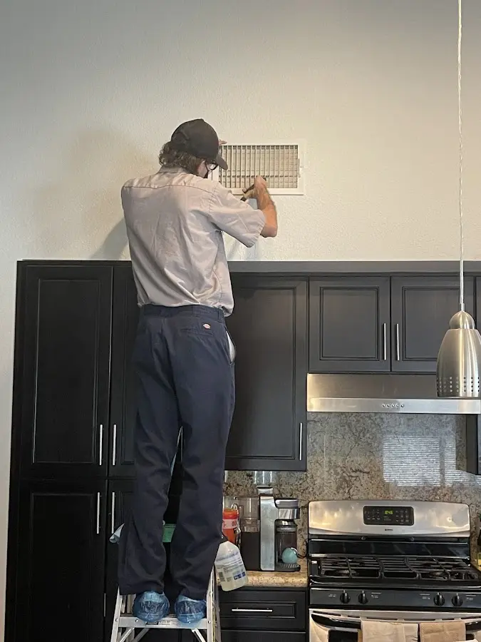 Technician inspecting an air vent during HVAC service in Rittman